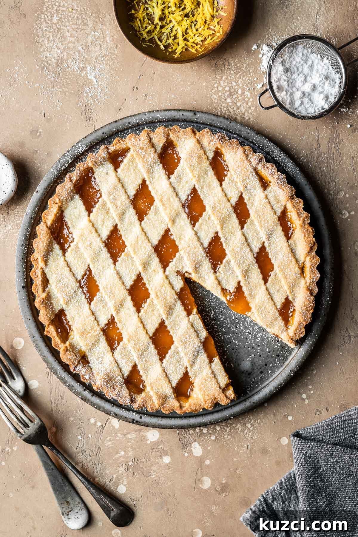 A lattice topped crostata di marmellata with one slice removed.