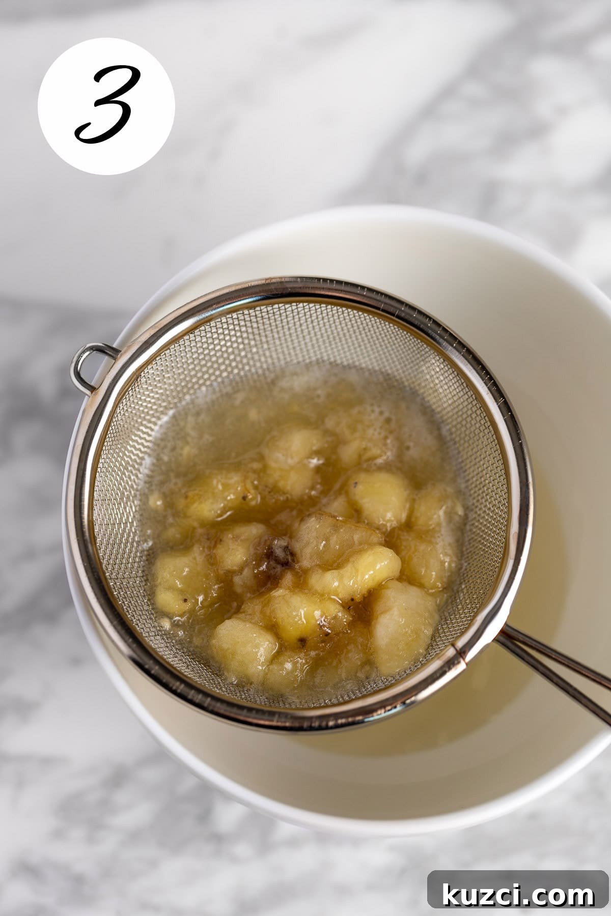 Homemade Banana Syrup for Pancakes, Cocktails and Desserts 6 Process photo showing the banana chunks being strained out of the syrup.