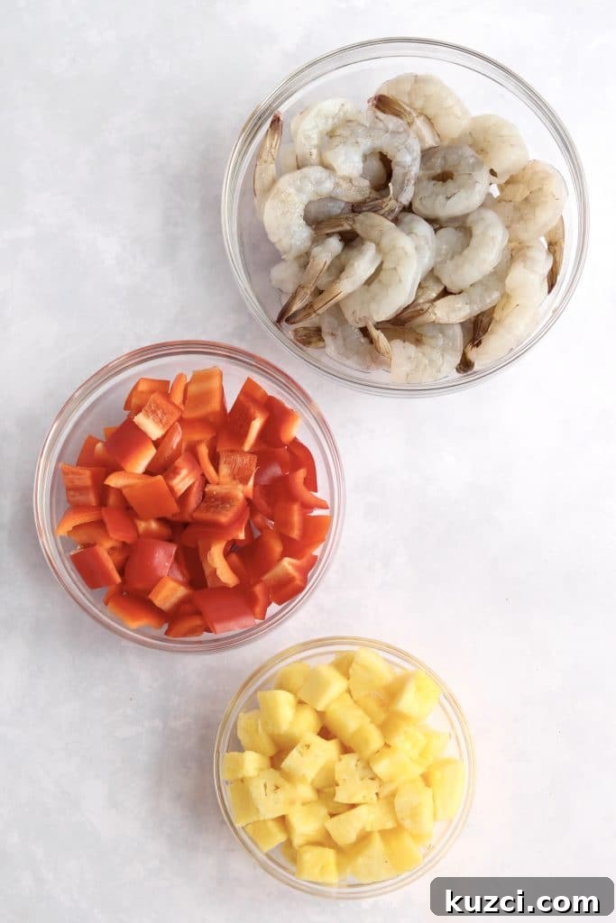 Sheet Pan Shrimp with Pineapple and Garlic Lime Glaze 3 Raw shrimp, red bell pepper, and pineapple in prep bowls.