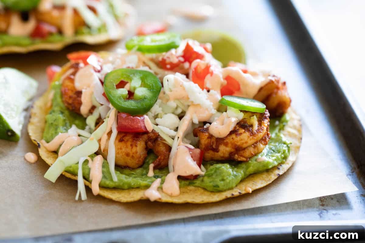 Shrimp tostada topped with jalapenos and homemade sauce on parchment paper.
