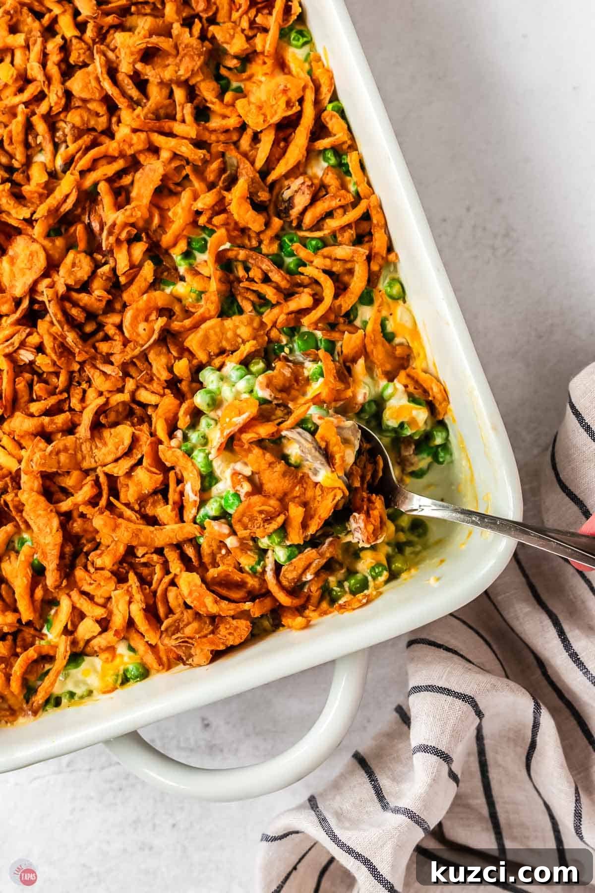 overhead picture of spoon scooping casserole out of a white dish