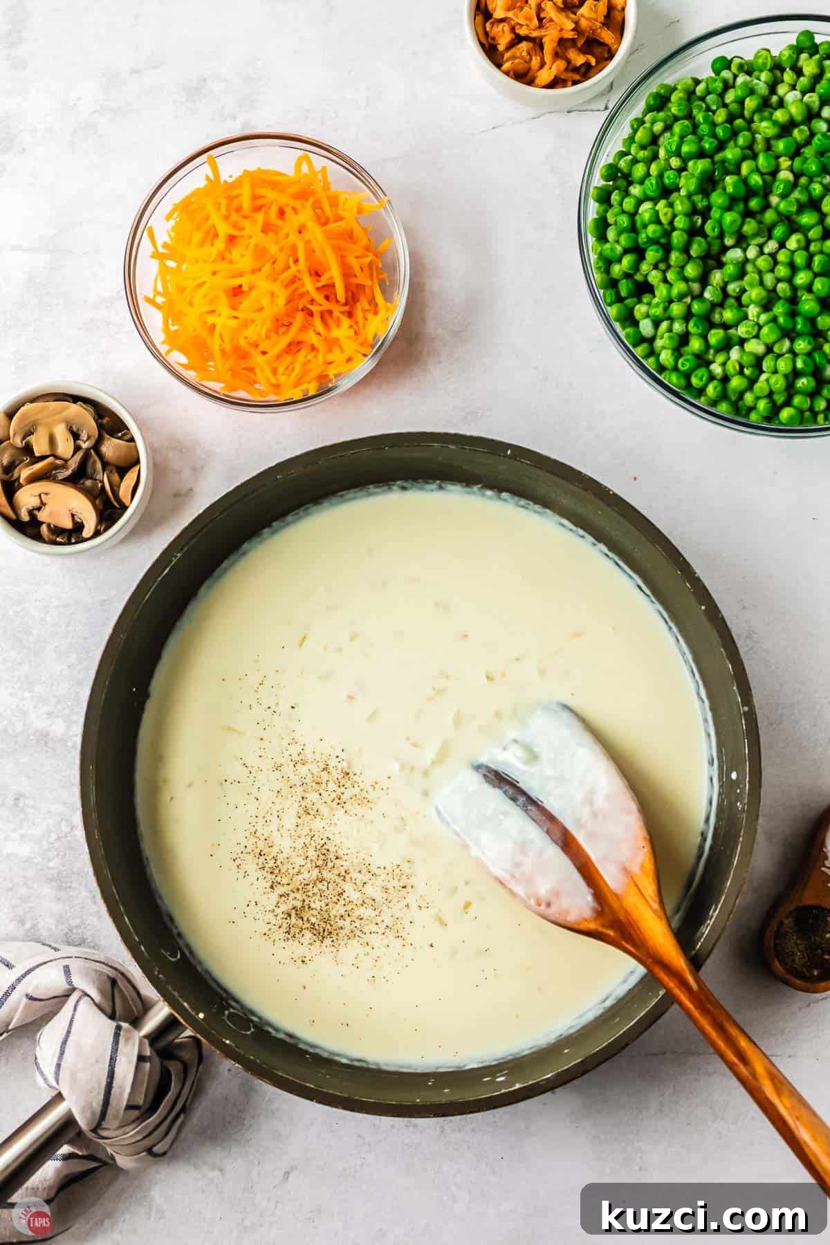 skillet with roux and a wood spoon with a line in the roux scraped off