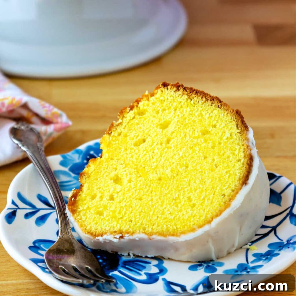 Zesty Lemon Pound Cake for Serious Lemon Lovers 3 A bright yellow slice of lemon pound cake on a blue-patterned plate.