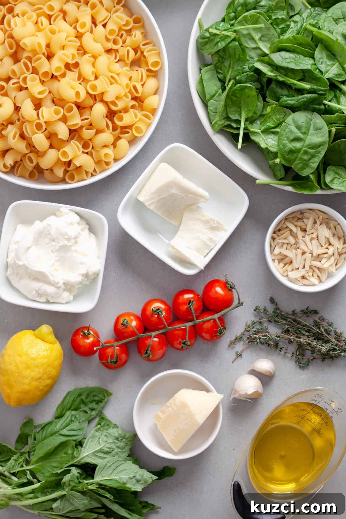Ingredients for ricotta pesto pasta on a gray table.