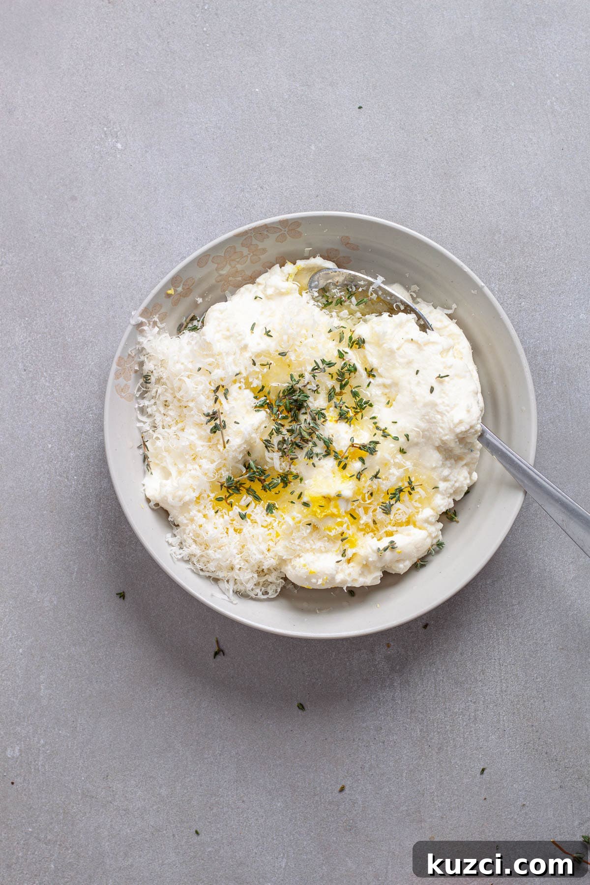 Ricotta cheese with herbs and lemon juice in a small bowl.