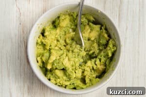 Tomato Goat Cheese Avocado Toast 11 Mashed avocado in a bowl.
