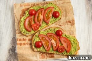 Tomato Goat Cheese Avocado Toast 13 Avocado toast topped with sliced tomatoes.