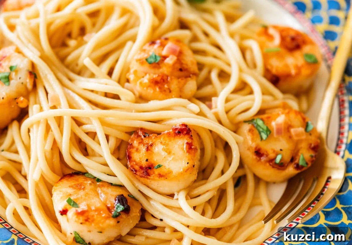 Scallop Pasta with Lemon Garlic Sauce 2 A single serving of scallop pasta on a plate with garnish.