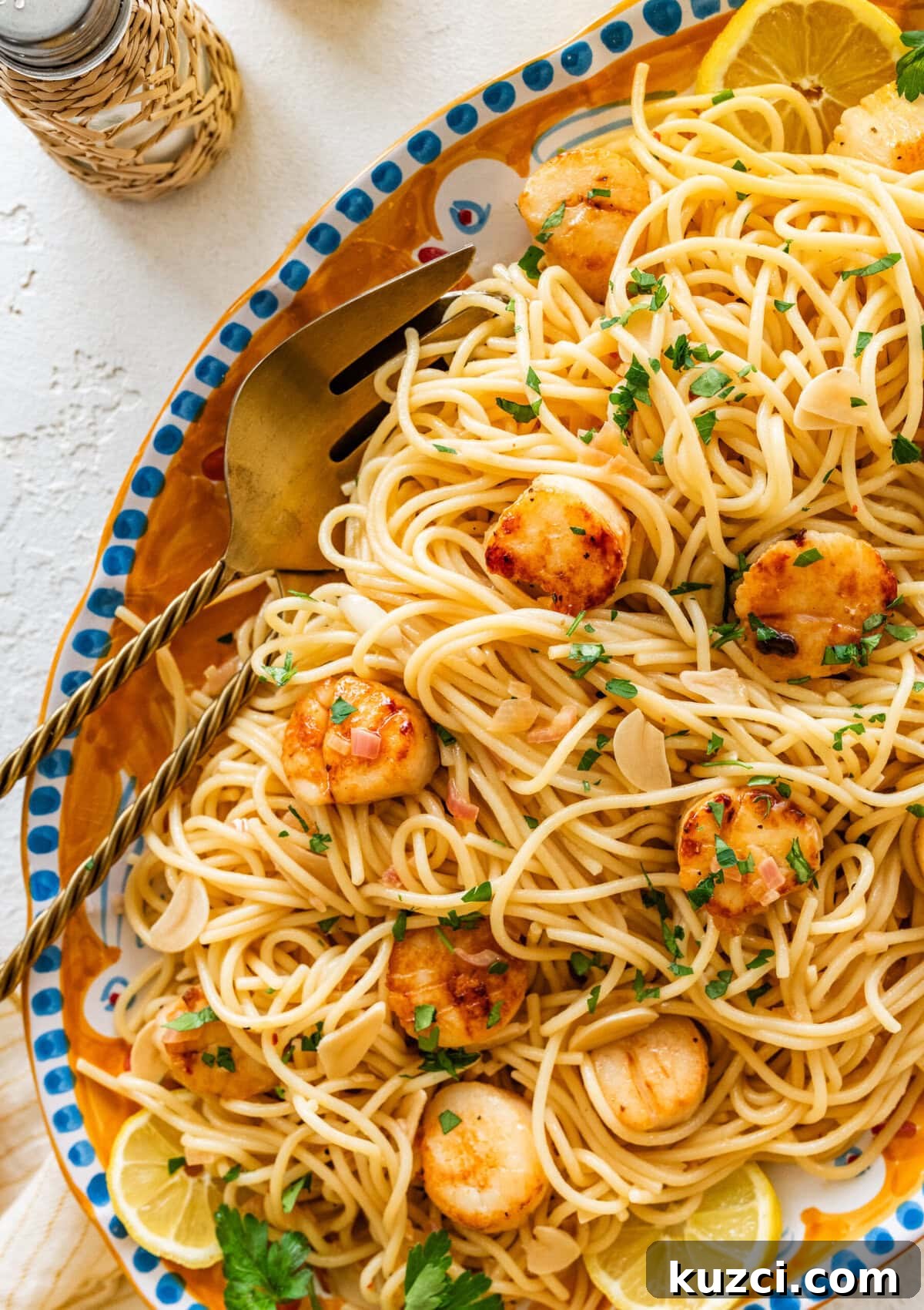 Scallop Pasta with Lemon Garlic Sauce 13 Scallop pasta on a serving plate with utensils.