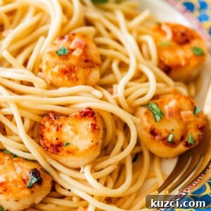 Scallop Pasta with Lemon Garlic Sauce 14 A single serving of scallop pasta on a plate with garnish.