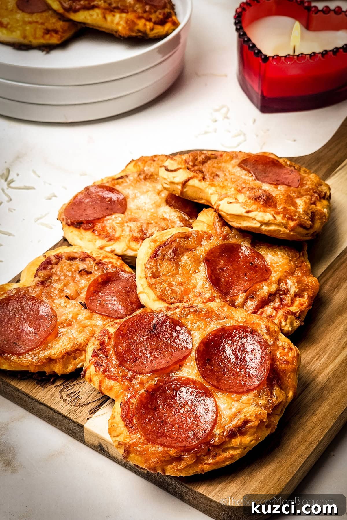 a wooden board piled with heart shaped mini pizzas.