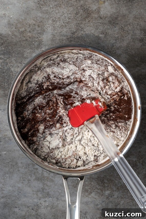 Make the brownie batter. Flour stirred into brownie batter in a saucepan.