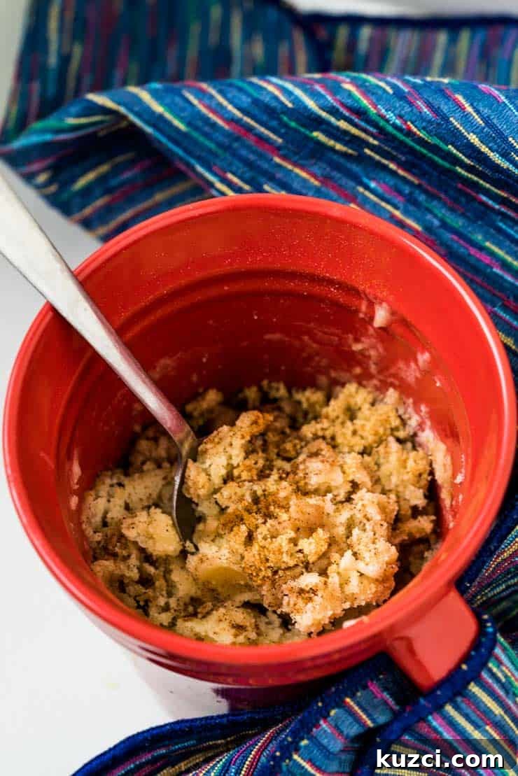 Microwave Coffee Cake in a Mug 3 Red mug and spoon with microwave coffee cake in it.