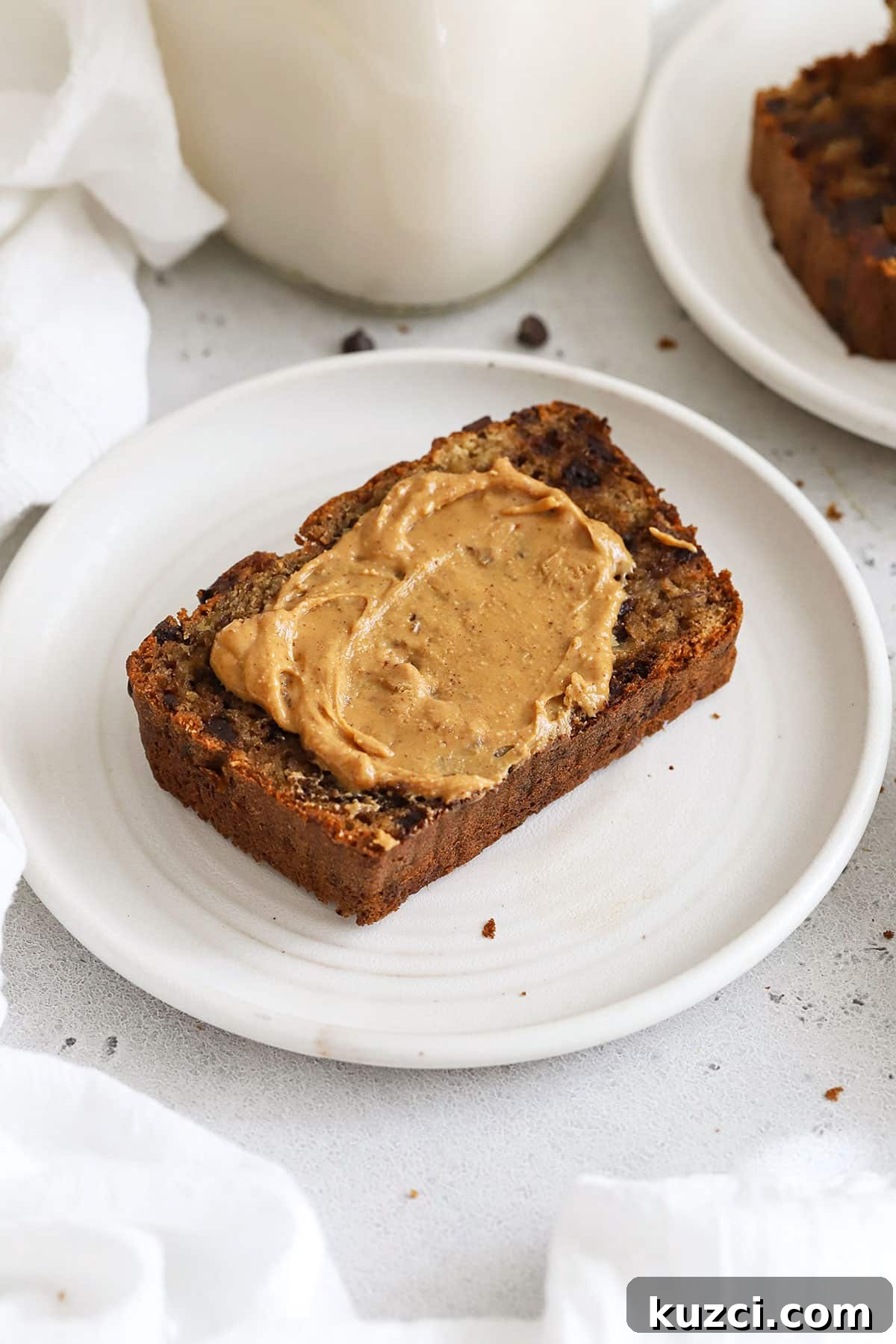 a piece of gluten-free banana bread spread with peanut butter