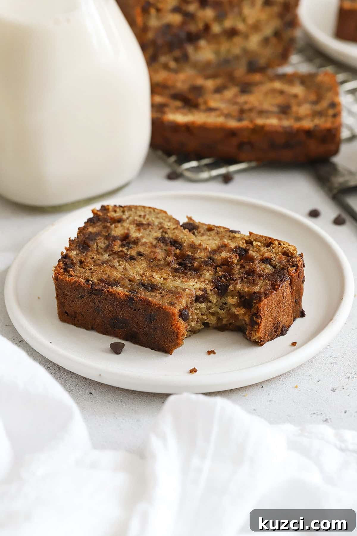 a slice of gluten-free chocolate chip banana bread with a bite taken out of it