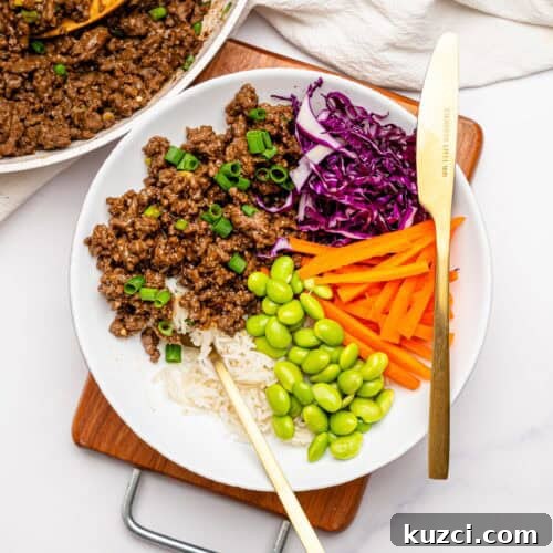 High Protein Teriyaki Beef Bowls for Meal Prep 13 Teriyaki Beef Bowls with rice and crunchy veggies in a white bowl.