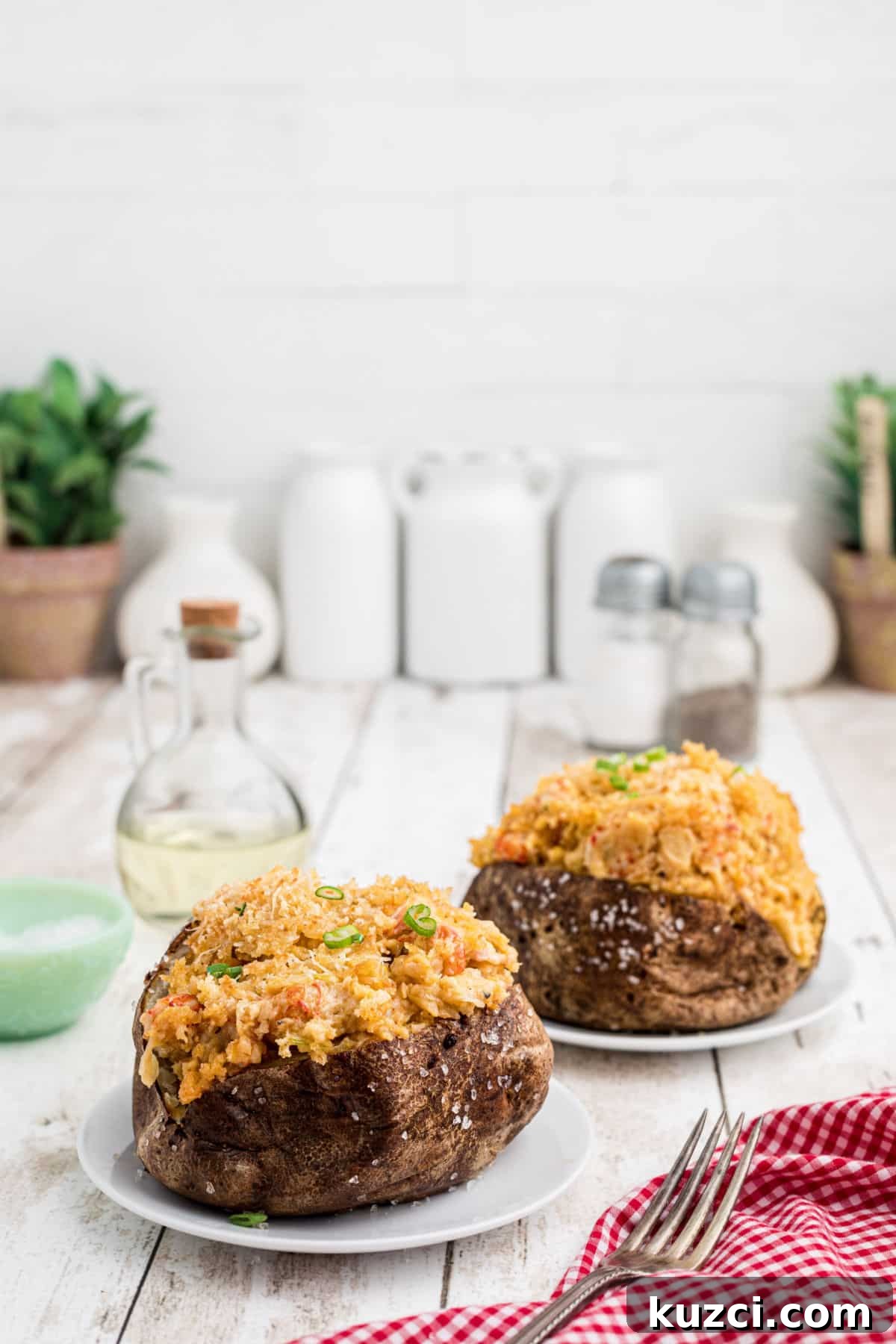 Crawfish-Stuffed Baked Potatoes Recipe 12 Side shot of two crawfish baked potato on plates.